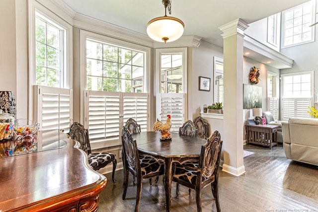 dining room featuring ornate columns, ornamental molding, plenty of natural light, and dark hardwood / wood-style floors