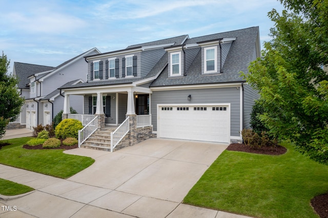 view of front of home with a porch, a garage, and a front yard