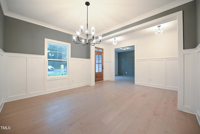 interior space featuring light hardwood / wood-style floors, ornamental molding, and a chandelier