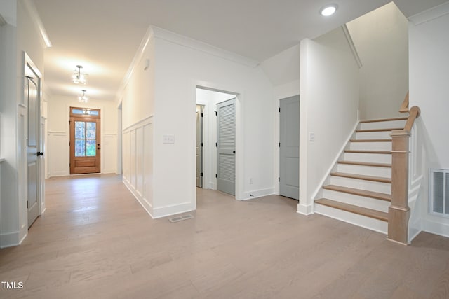 hall featuring light hardwood / wood-style floors and ornamental molding