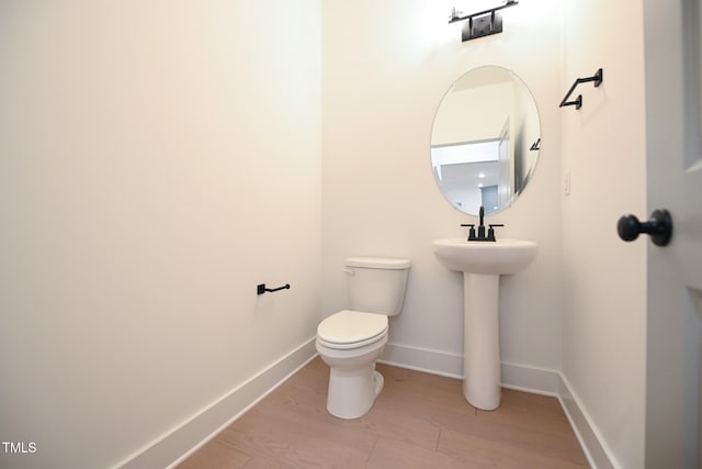 bathroom featuring toilet and wood-type flooring