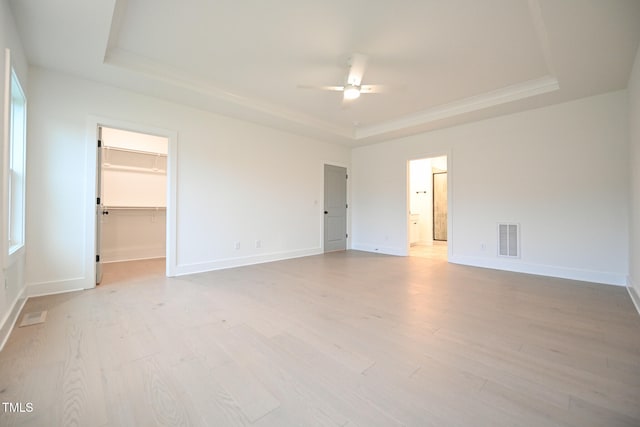 interior space featuring a tray ceiling, ceiling fan, and light hardwood / wood-style floors