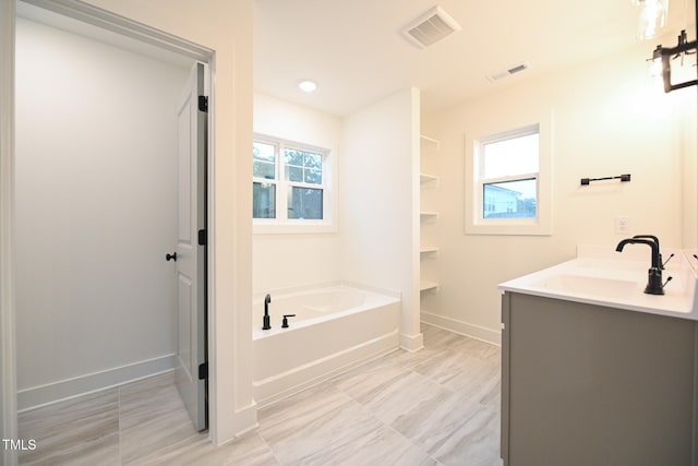 bathroom featuring vanity and a tub to relax in