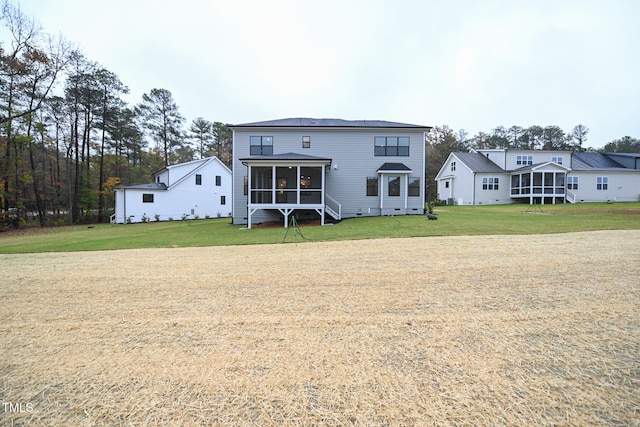 rear view of house with a yard and a sunroom