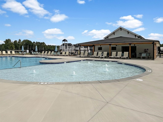 view of swimming pool with pool water feature and a patio