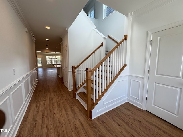 stairs with hardwood / wood-style flooring and ornamental molding