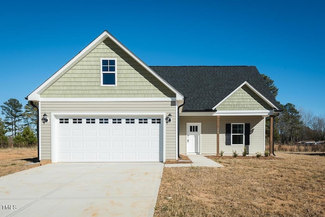 view of front of property featuring driveway and roof with shingles