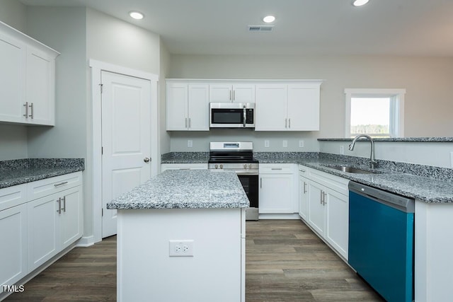 kitchen with a sink, visible vents, white cabinets, appliances with stainless steel finishes, and dark wood finished floors