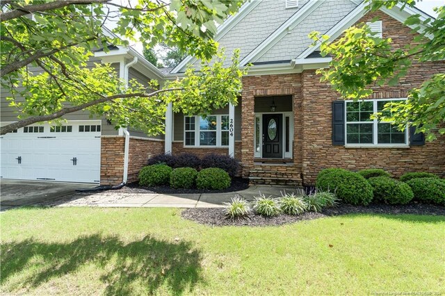 craftsman inspired home with a garage and a front lawn