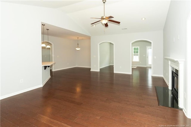 unfurnished living room featuring dark wood-type flooring, ceiling fan, and vaulted ceiling