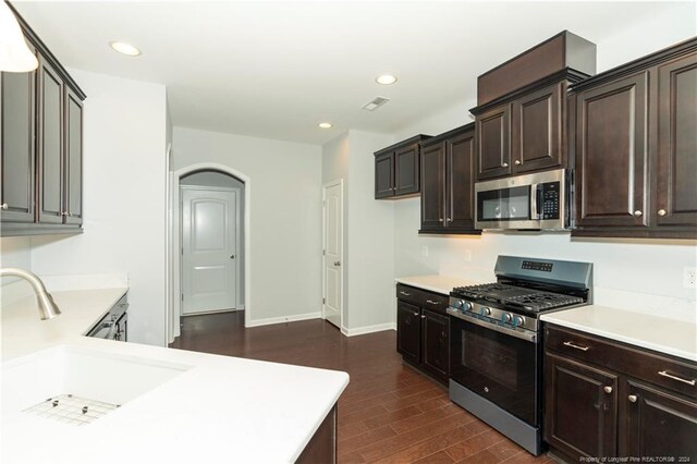 kitchen featuring dark brown cabinetry, sink, dark hardwood / wood-style floors, and stainless steel appliances