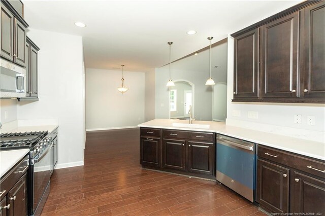 kitchen featuring gas stove, dishwasher, dark hardwood / wood-style flooring, dark brown cabinetry, and sink