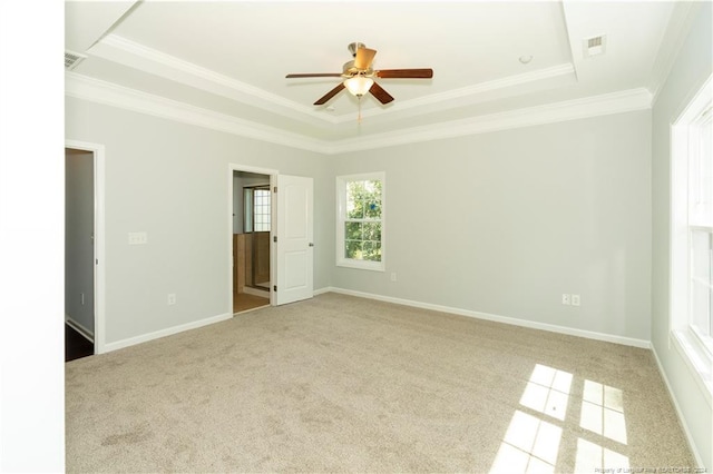 unfurnished bedroom with crown molding, light carpet, ceiling fan, and a raised ceiling