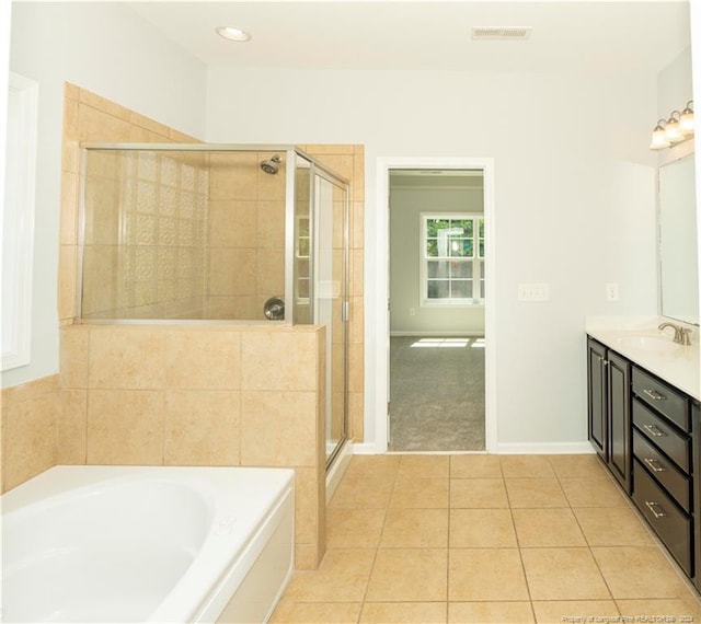 bathroom featuring tile patterned flooring, independent shower and bath, and vanity