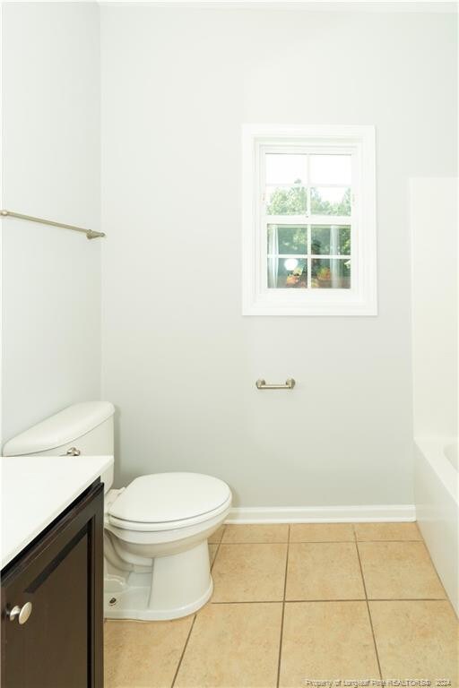 full bathroom with vanity, washtub / shower combination, tile patterned flooring, and toilet