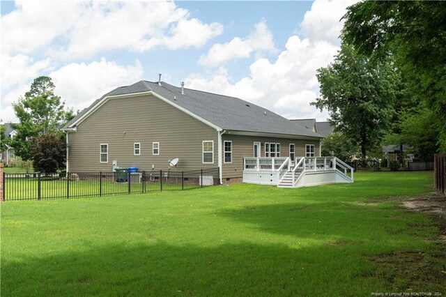 back of property featuring a yard and a wooden deck