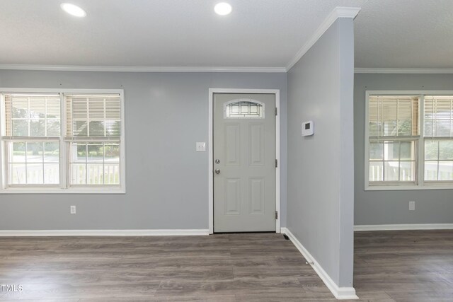 foyer entrance with crown molding and hardwood / wood-style floors