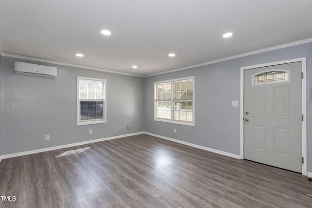 foyer entrance featuring a wall mounted air conditioner, hardwood / wood-style floors, and a wealth of natural light