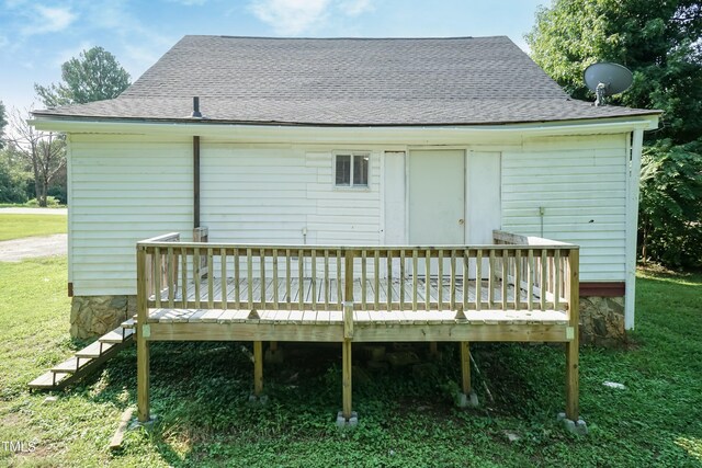 rear view of property with a deck and a lawn