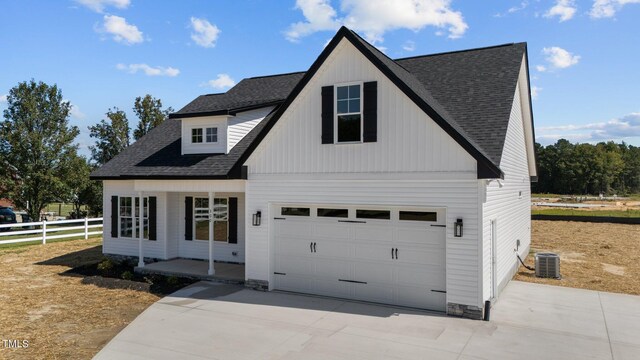 view of front of home featuring a garage, a porch, and central air condition unit