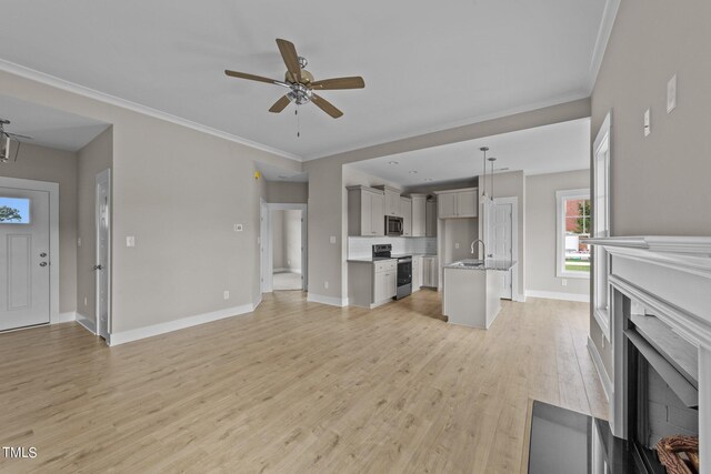 unfurnished living room featuring ceiling fan, sink, crown molding, and light hardwood / wood-style floors