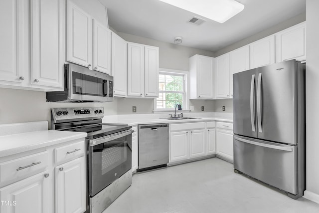 kitchen featuring appliances with stainless steel finishes, sink, and white cabinets