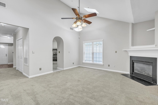 unfurnished living room featuring ceiling fan, high vaulted ceiling, and carpet