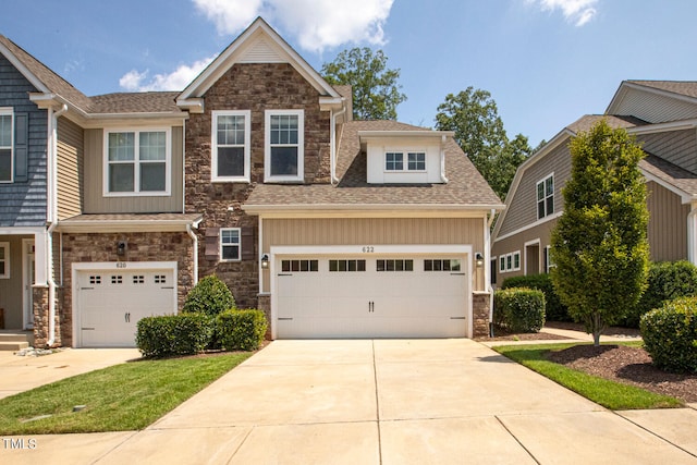 craftsman house with a garage, stone siding, driveway, and roof with shingles