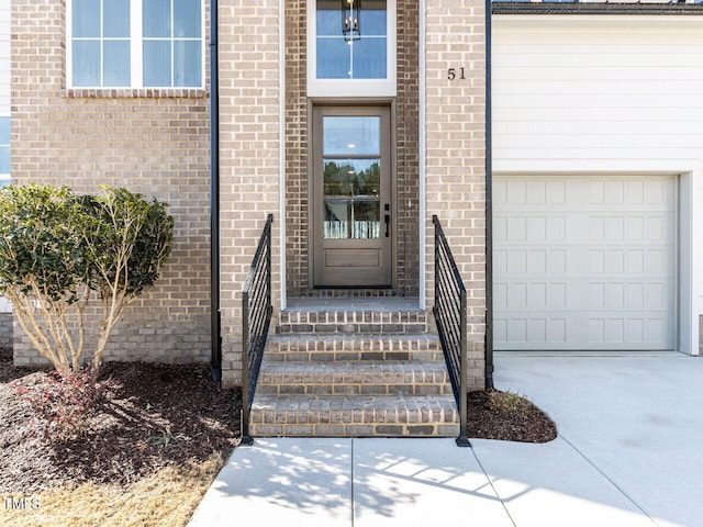 entrance to property featuring a garage and driveway