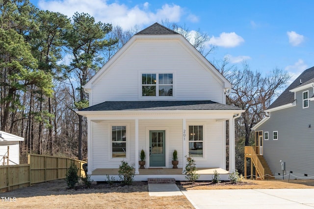 view of front of house featuring a porch, roof with shingles, and fence