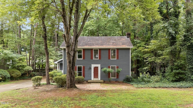 colonial inspired home featuring a front lawn