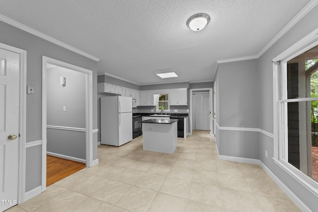 kitchen with white appliances, ornamental molding, and white cabinets