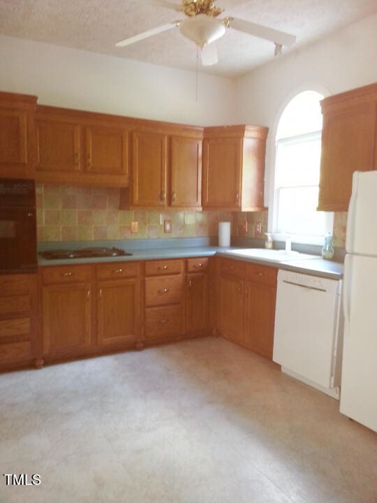 kitchen with tasteful backsplash, sink, white appliances, and ceiling fan