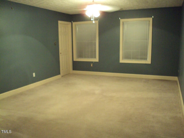 empty room with carpet and a textured ceiling