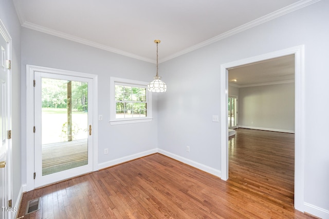 empty room with ornamental molding and hardwood / wood-style floors