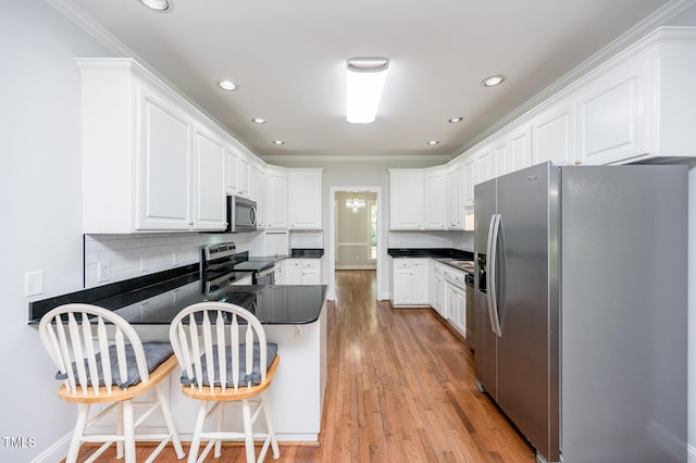 kitchen with tasteful backsplash, stainless steel appliances, crown molding, light wood-type flooring, and a breakfast bar area