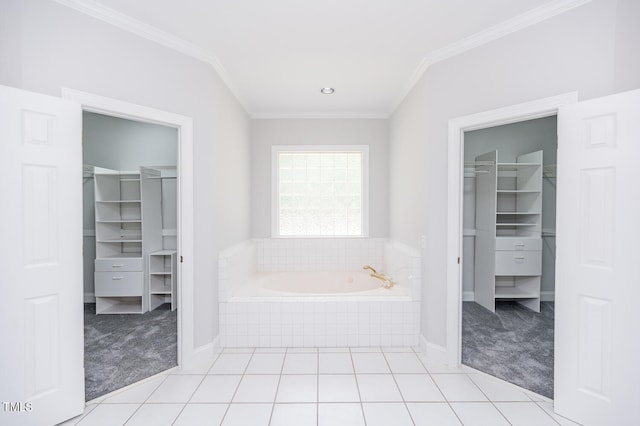 bathroom featuring tile patterned flooring, tiled tub, and ornamental molding