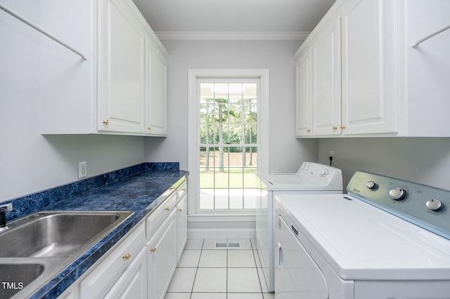 clothes washing area with washer and clothes dryer, light tile patterned floors, cabinets, sink, and ornamental molding