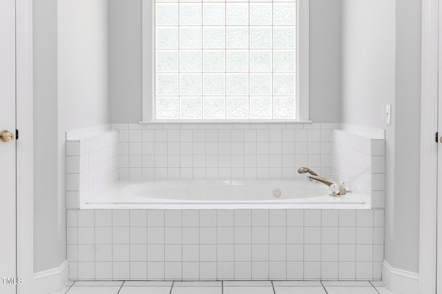 bathroom featuring a wealth of natural light, tiled tub, and tile patterned floors