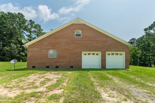 view of side of home featuring a garage and a lawn