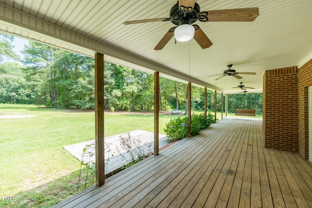 wooden deck with a yard and ceiling fan