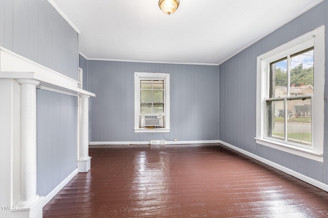 unfurnished living room with cooling unit, crown molding, baseboards, and hardwood / wood-style flooring