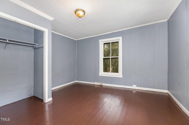 unfurnished bedroom featuring ornamental molding, a closet, and wood-type flooring