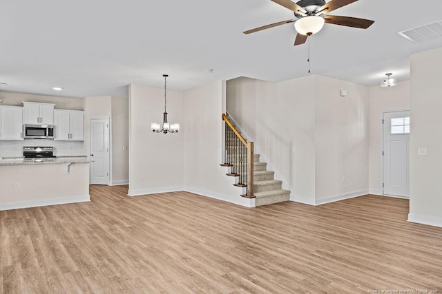 unfurnished living room featuring light hardwood / wood-style floors and ceiling fan with notable chandelier