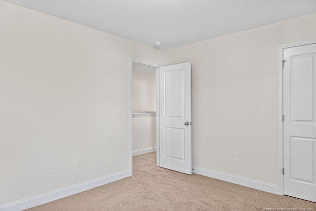 unfurnished room featuring light carpet