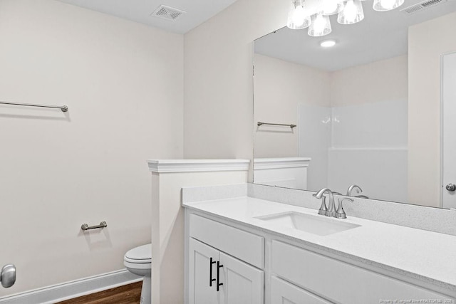 bathroom with wood-type flooring, vanity, and toilet