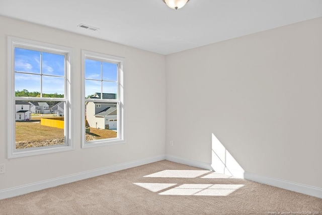 unfurnished room featuring light carpet