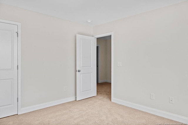 spare room featuring light colored carpet