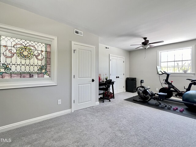 exercise room with light carpet and ceiling fan