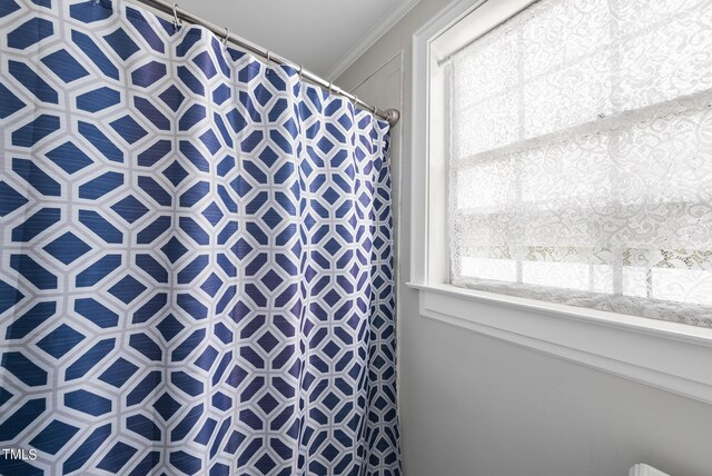 bathroom with crown molding and a shower with shower curtain